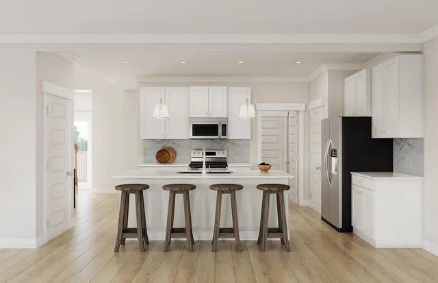 a kitchen with stainless steel appliances a stove a refrigerator a microwave a sink and white cabinets with wooden floor