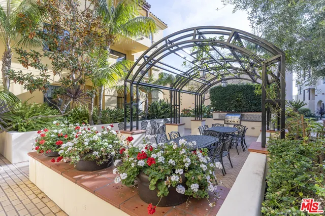 a view of a patio with a table and chairs and potted plants