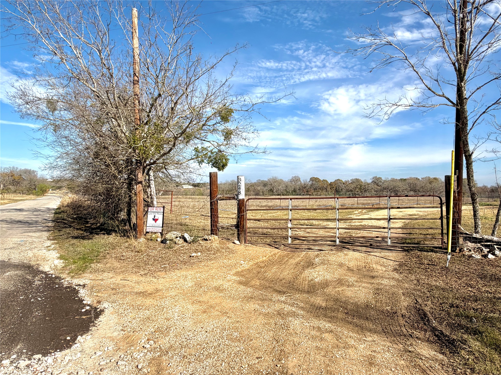 View of yard with a gate and a view of rural / pastoral area
