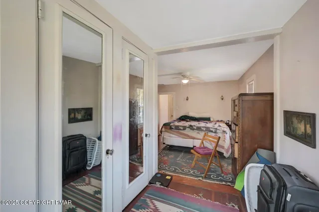 a view of a hallway with wooden floor and a livingroom