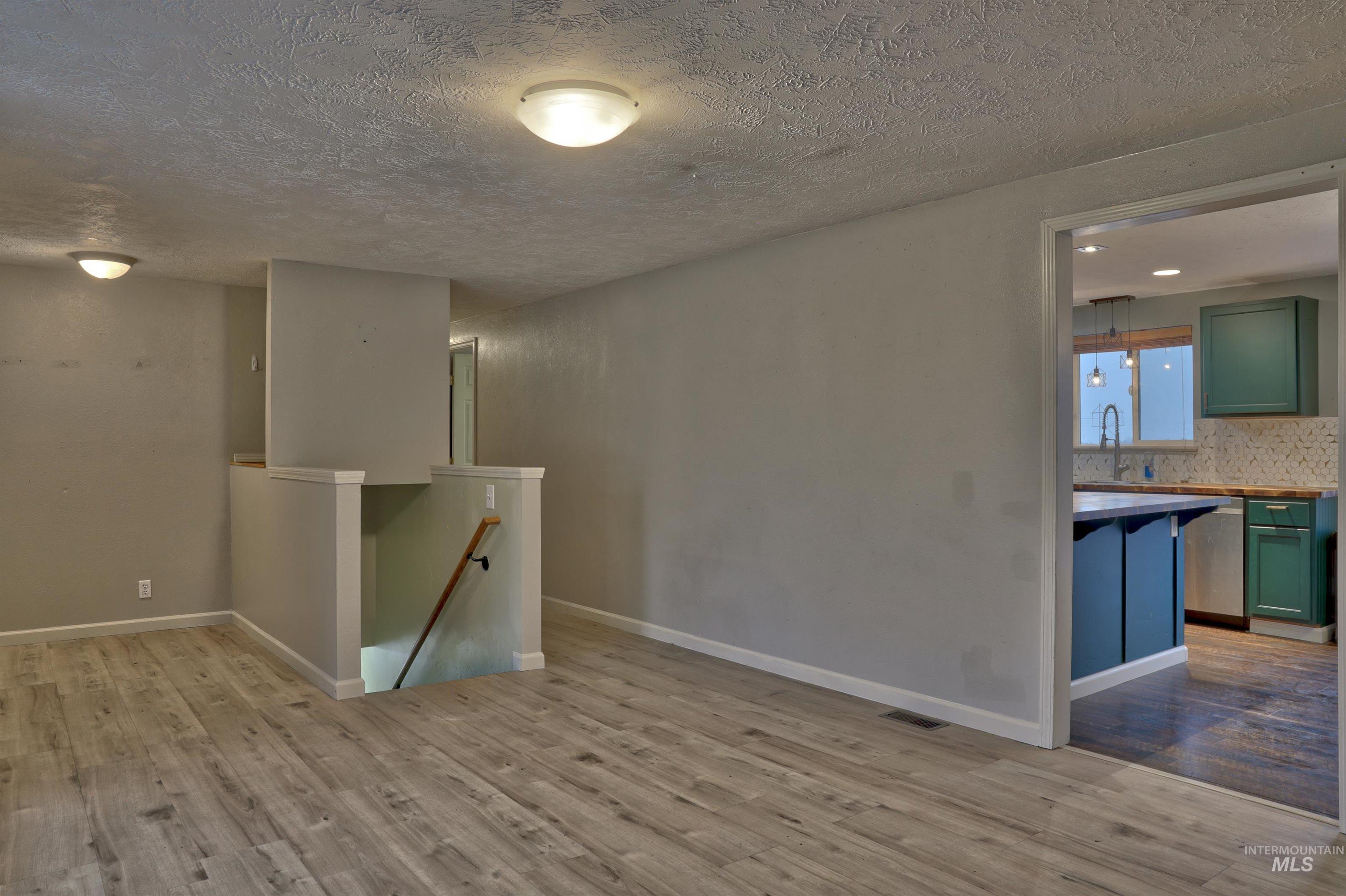 526 Ridge Drive Nampa, ID 83686 - Photo 8 of 21 Empty room with a textured ceiling and light wood-type flooring