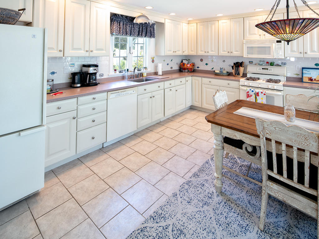 409 Monomoscoy Road Mashpee, MA 02649 - Photo 11 of 16 a kitchen with stainless steel appliances cabinets a sink and a window