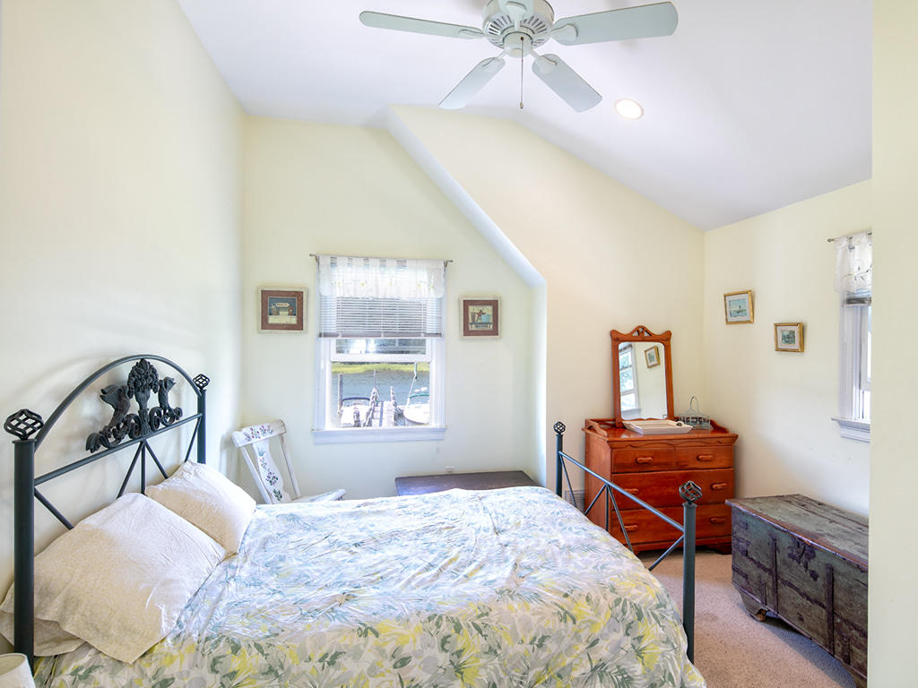409 Monomoscoy Road Mashpee, MA 02649 - Photo 14 of 16 a bedroom with a bed and a dresser in it