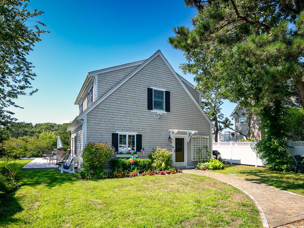 409 Monomoscoy Road Mashpee, MA 02649 - Photo 5 of 16 a front view of a house with a yard and garage