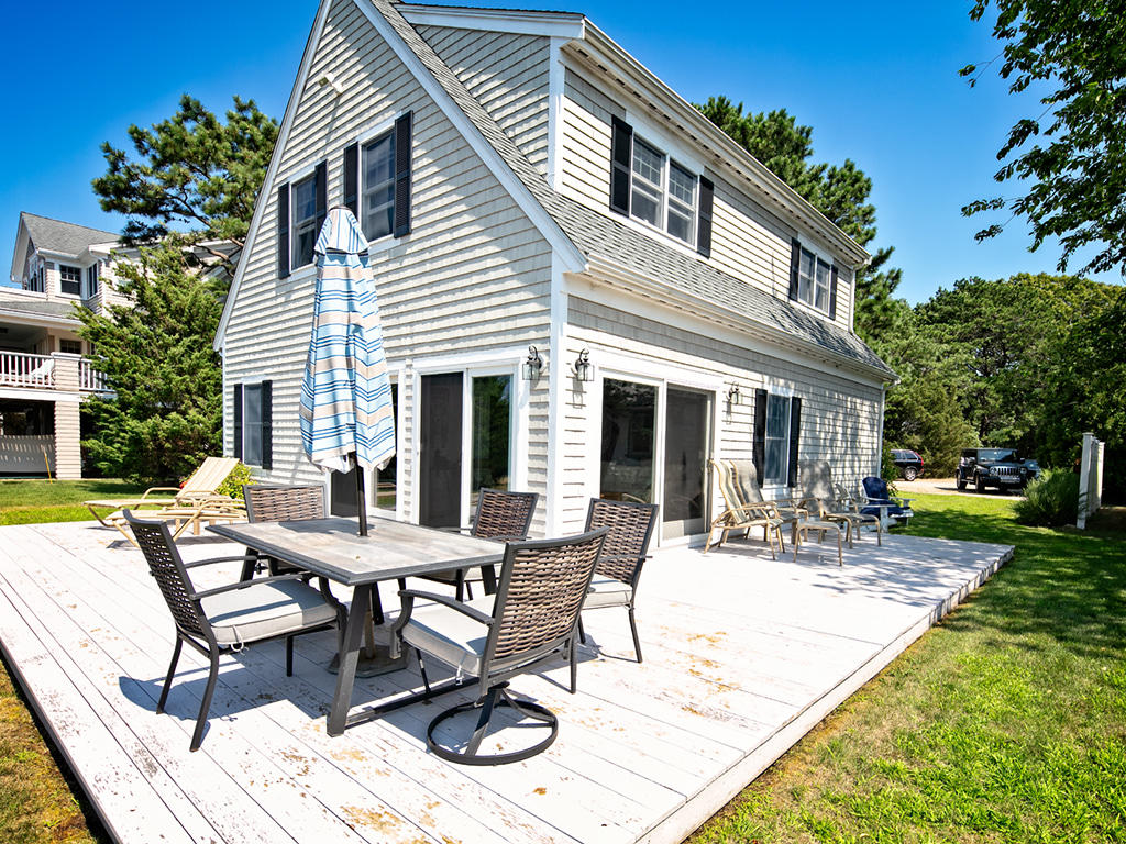 409 Monomoscoy Road Mashpee, MA 02649 - Photo 6 of 16 a view of a house with backyard sitting area and garden