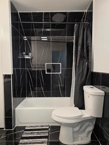a bathroom with a toilet and a shower