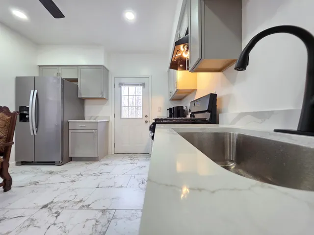 a kitchen with stainless steel appliances granite countertop a sink a stove and refrigerator