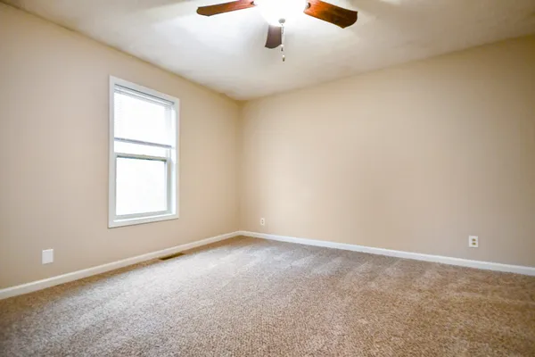 an empty room with windows and closet