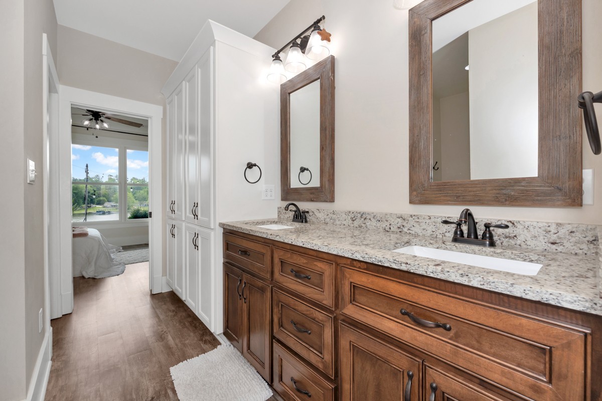 793 Davis Road Rogersville, AL 35652 - Photo 32 of 48 a spacious bathroom with a granite countertop double vanity sink a mirror and a shower