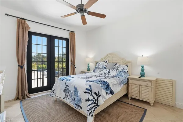 a bedroom with two beds and a ceiling fan