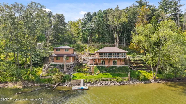 a aerial view of a house with a yard and lake view