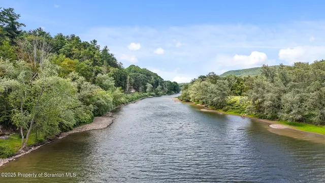 a backyard of a house with lots of green space and lake view