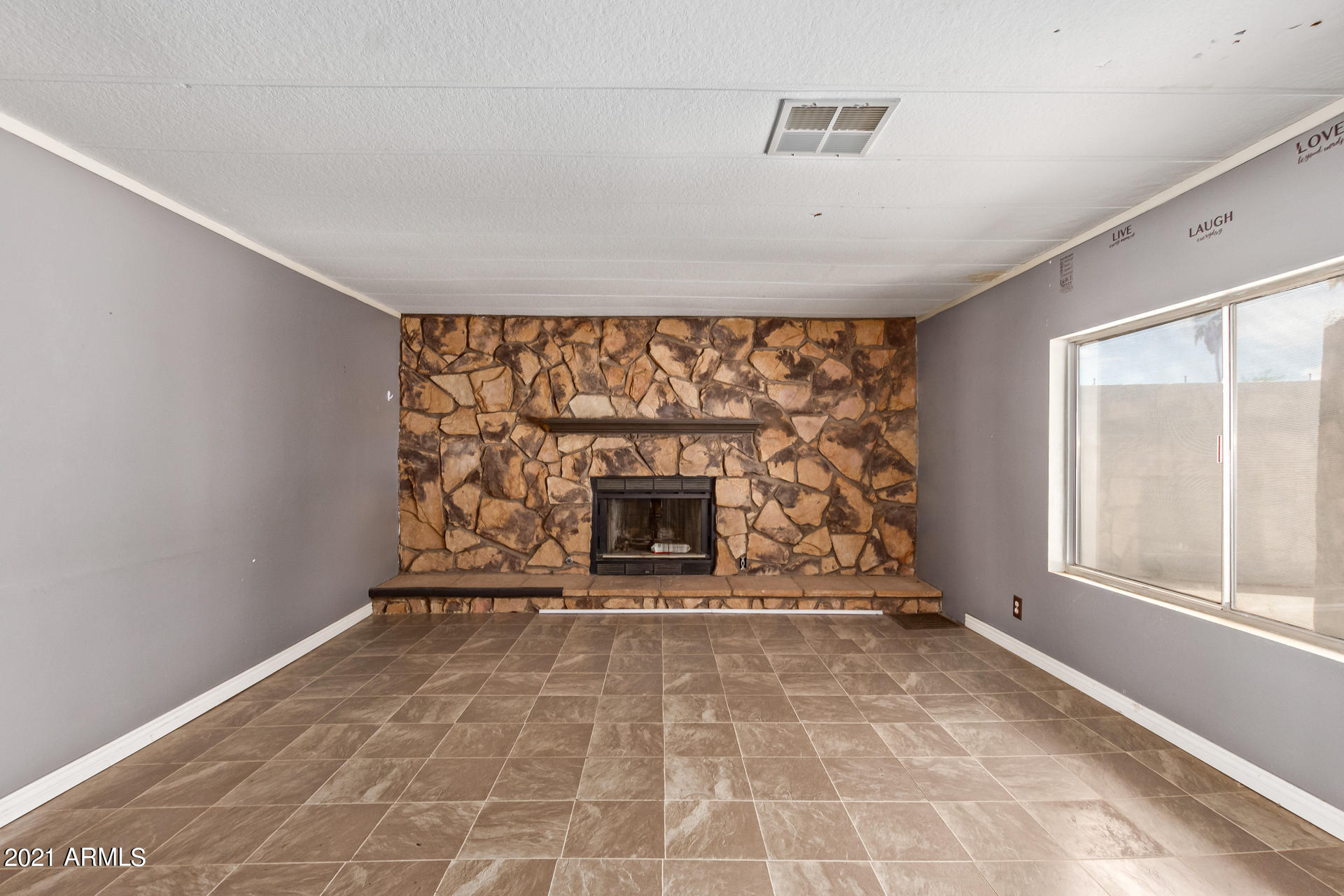 18835 North 25th Way Phoenix, AZ 85050 - Photo 5 of 24 a view of an empty room with a fireplace and a window