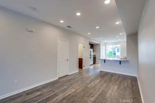 a view of a big room with wooden floor and windows