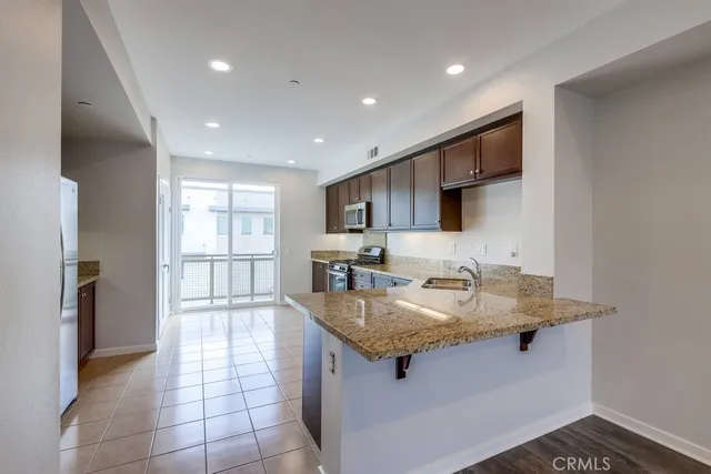 a kitchen with stainless steel appliances granite countertop a sink stove and cabinets