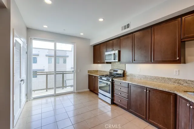a large kitchen with stainless steel appliances granite countertop a stove and a sink