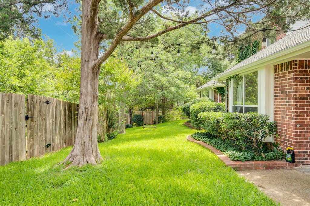 1907 Timber Ridge Court Cedar Hill, TX 75104 - Photo 29 of 30 Expansive yard featuring a wooden privacy fence, mature trees, and a brick exterior with large windows
