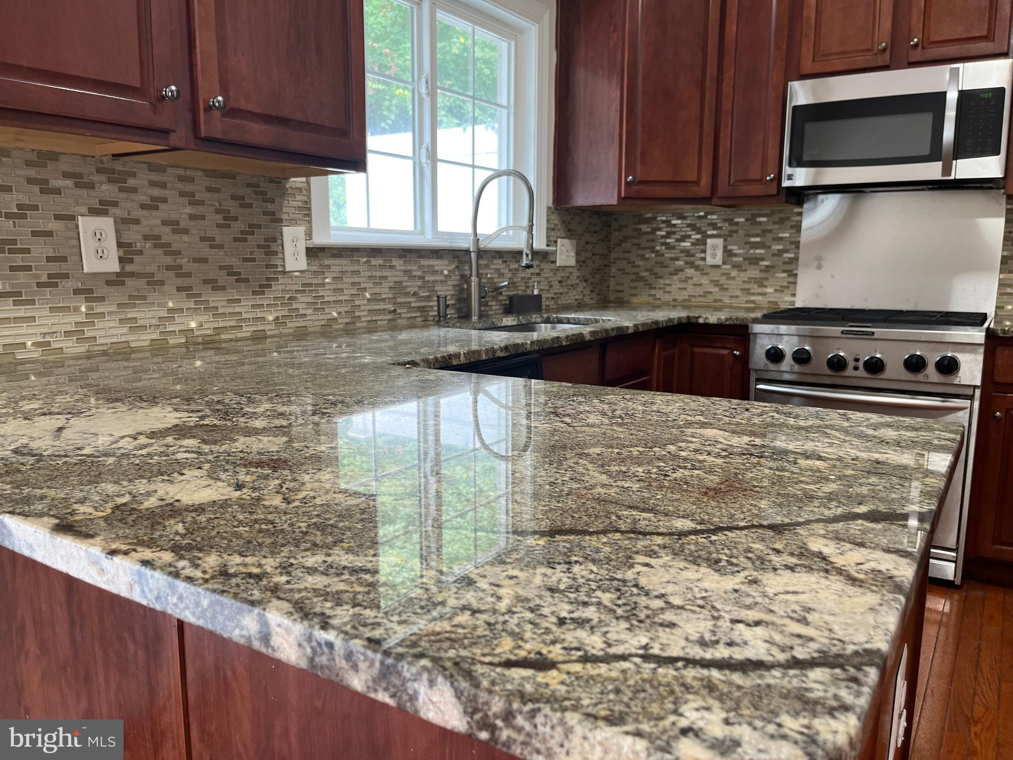 3316 Castle Ridge Circle, Unit 16 Silver Spring, MD 20904 - Photo 25 of 71 a kitchen with granite countertop a stove a sink and a microwave