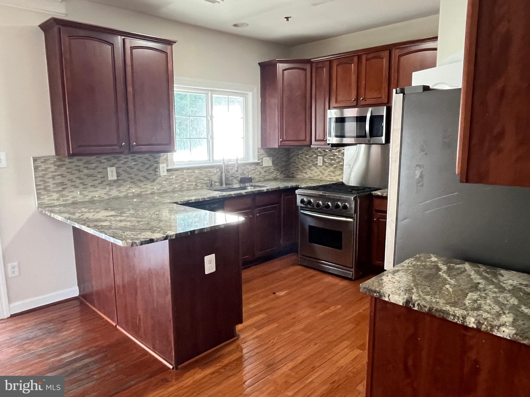 3316 Castle Ridge Circle, Unit 16 Silver Spring, MD 20904 - Photo 26 of 71 a kitchen with stainless steel appliances granite countertop a stove a sink and a microwave