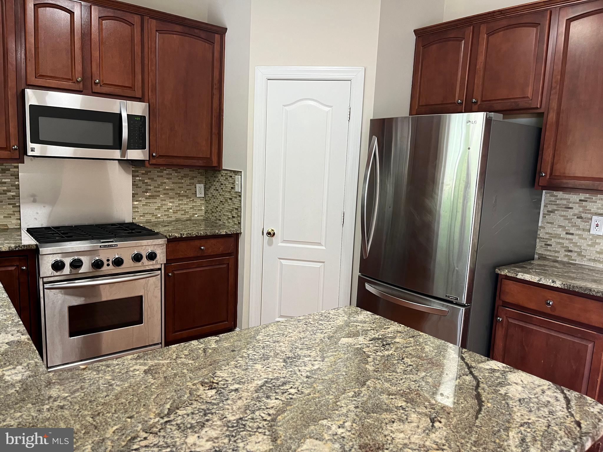 3316 Castle Ridge Circle, Unit 16 Silver Spring, MD 20904 - Photo 27 of 71 a kitchen with stainless steel appliances granite countertop a refrigerator stove and microwave