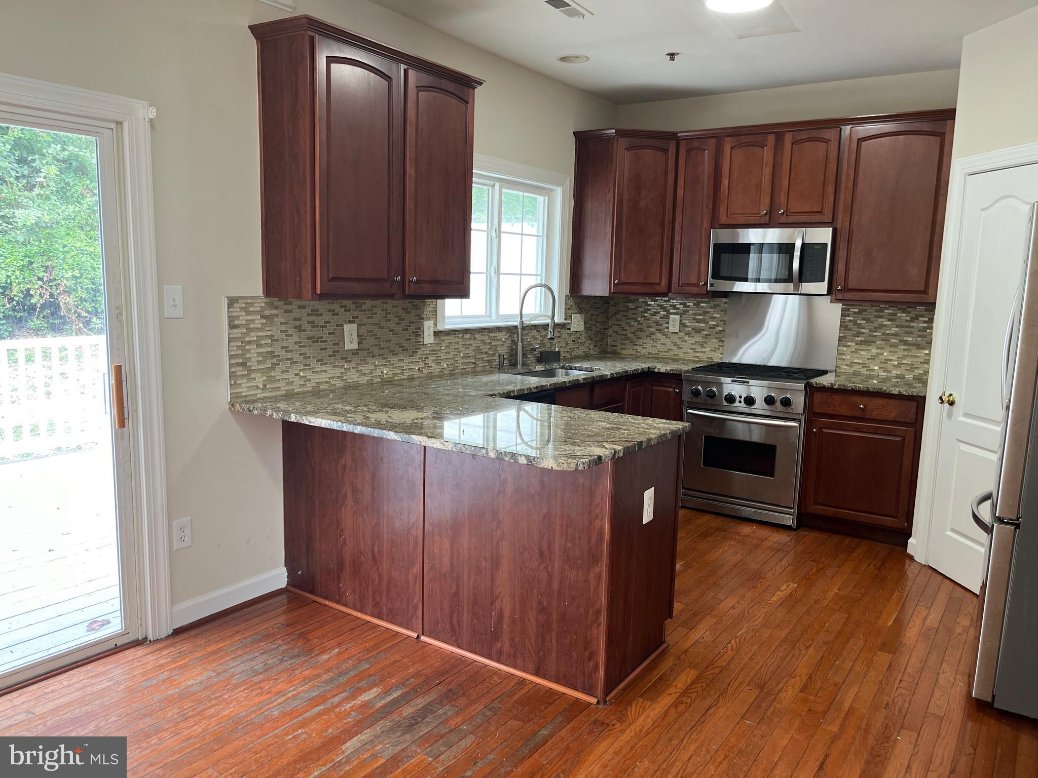 3316 Castle Ridge Circle, Unit 16 Silver Spring, MD 20904 - Photo 28 of 71 a kitchen with granite countertop wooden cabinets and a stainless steel appliances