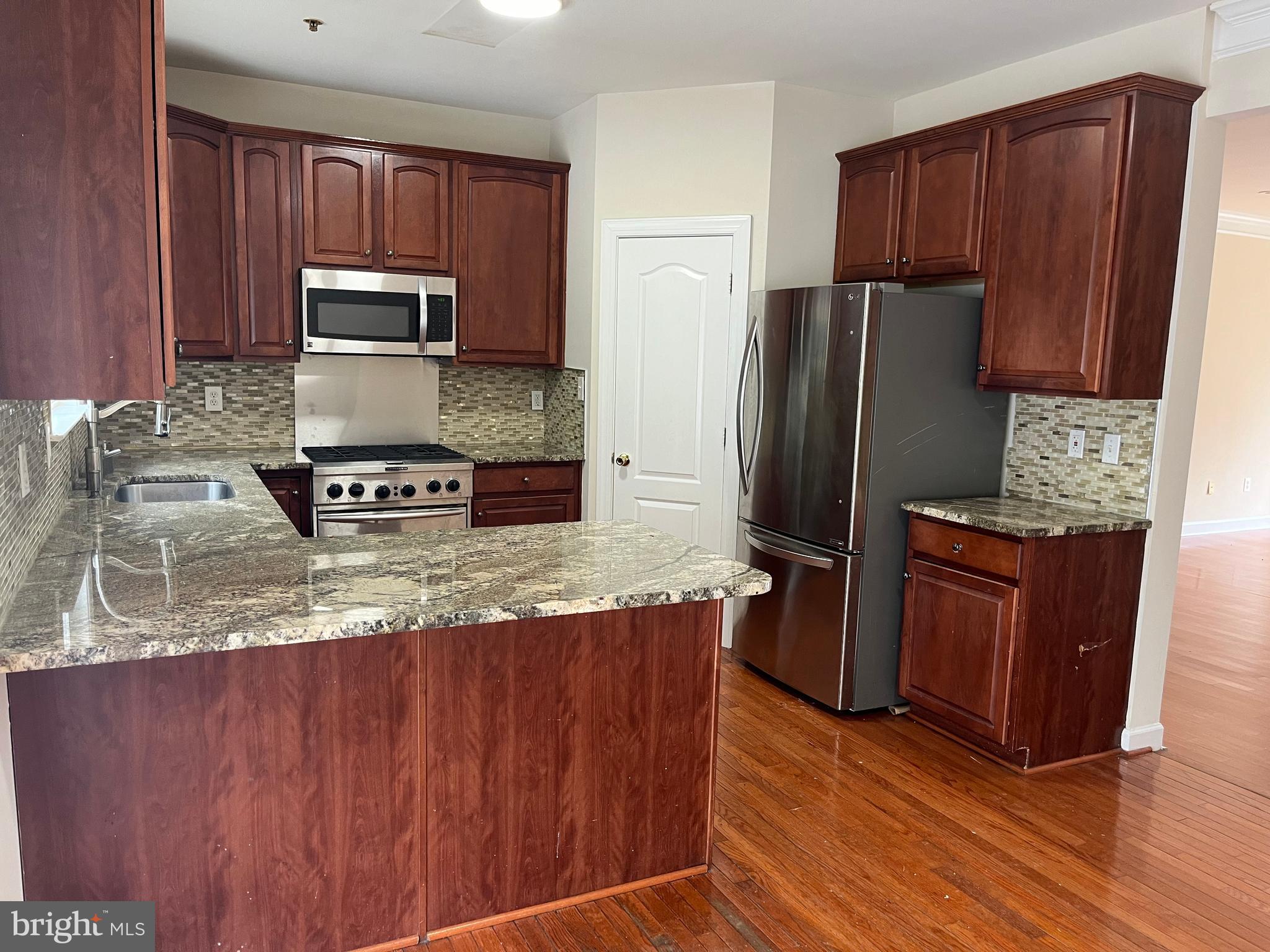 3316 Castle Ridge Circle, Unit 16 Silver Spring, MD 20904 - Photo 29 of 71 a kitchen with granite countertop wooden cabinets and stainless steel appliances