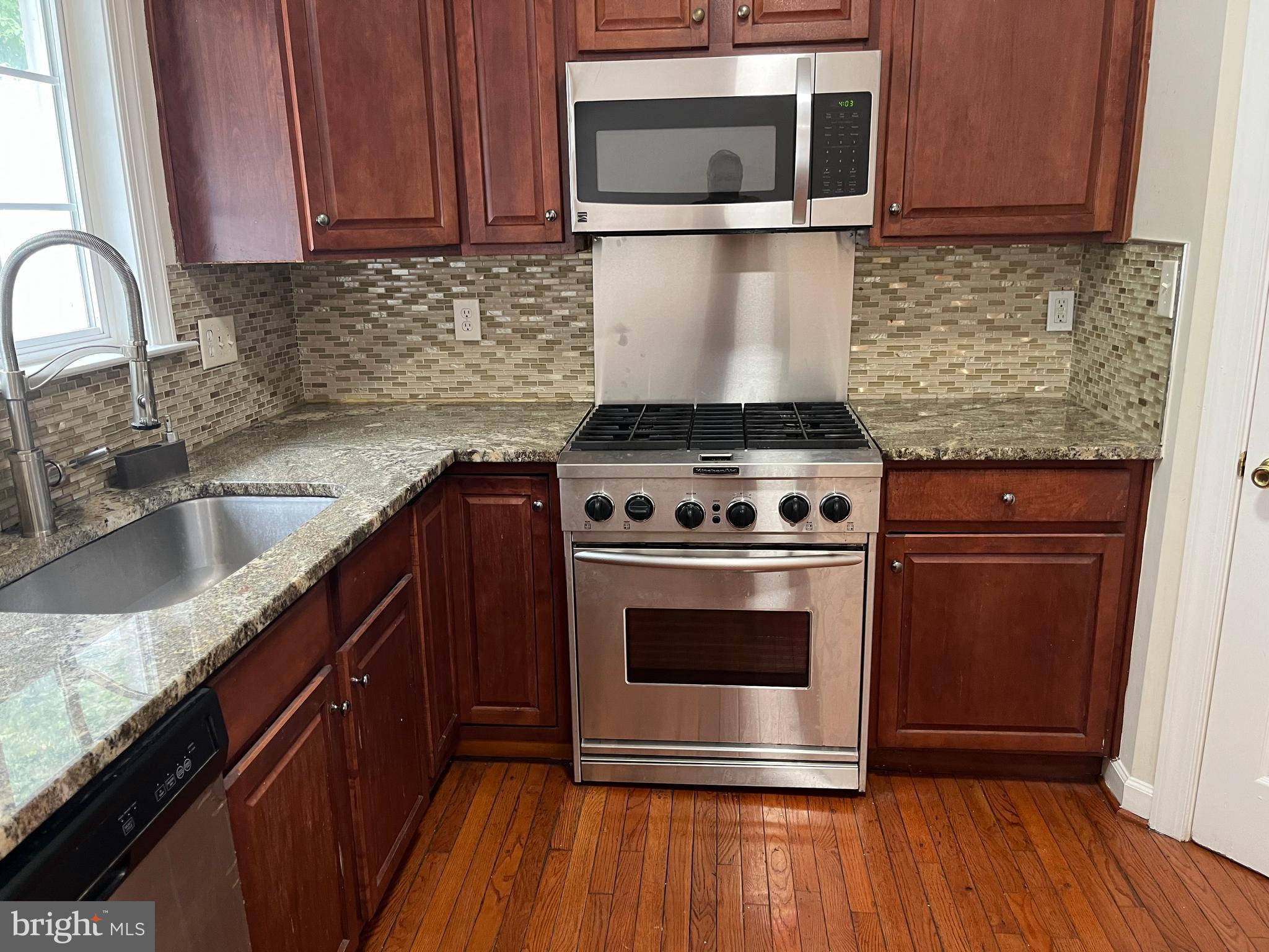 3316 Castle Ridge Circle, Unit 16 Silver Spring, MD 20904 - Photo 35 of 71 a kitchen with granite countertop wooden cabinets stainless steel appliances and a wooden floor