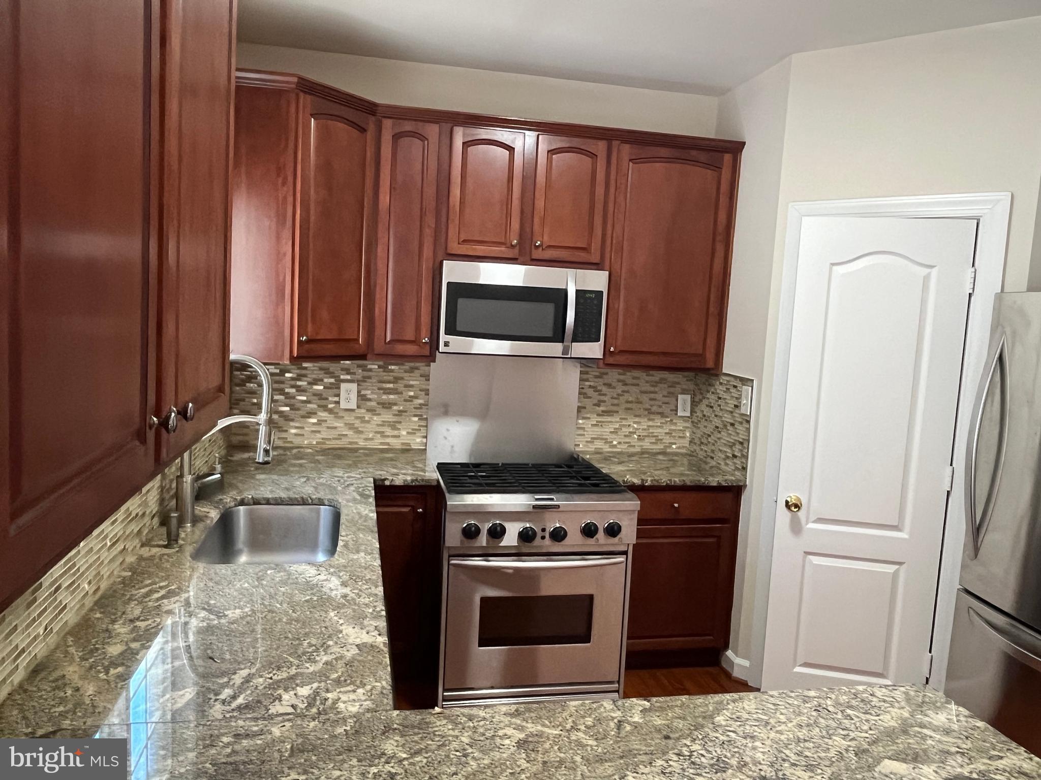 3316 Castle Ridge Circle, Unit 16 Silver Spring, MD 20904 - Photo 37 of 71 a kitchen with granite countertop a stove and a sink
