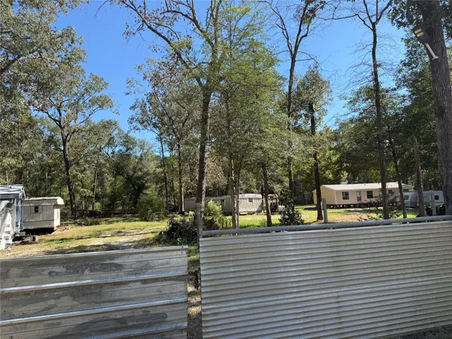 a view of swimming pool with sitting area and trees
