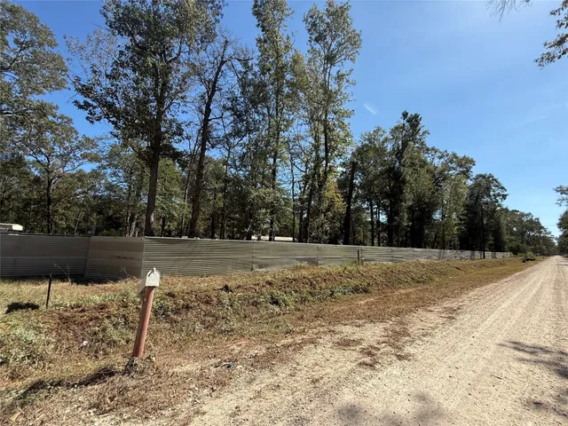 a view of dirt yard and covered with trees