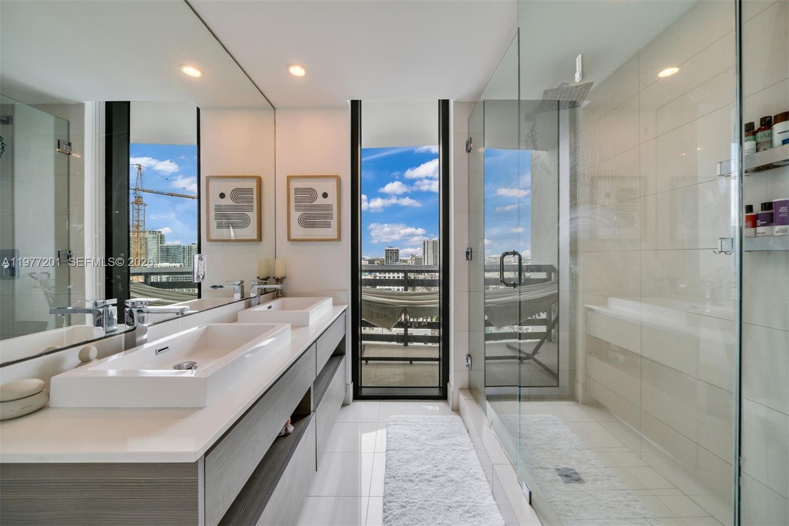 460 Northeast 28th Street, Unit 1901 Miami, FL 33137 - Photo 18 of 31 a bathroom with a double vanity sink shower and a mirror