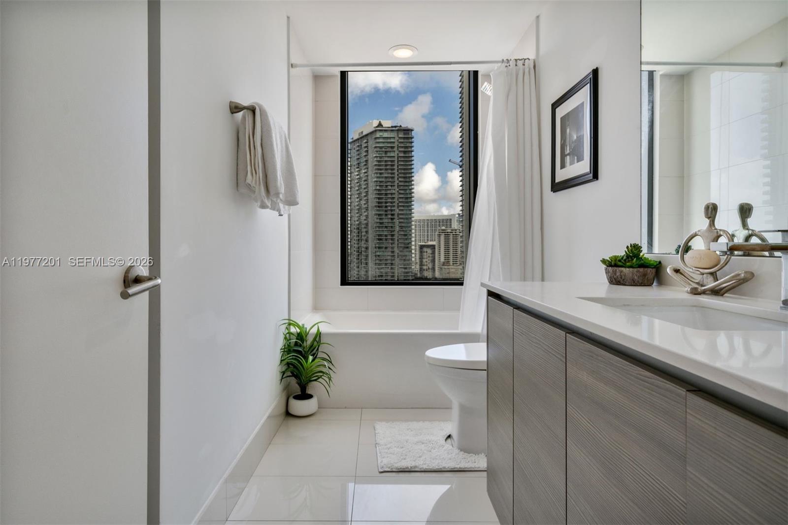 460 Northeast 28th Street, Unit 1901 Miami, FL 33137 - Photo 24 of 31 a bathroom with a granite countertop sink a toilet and shower