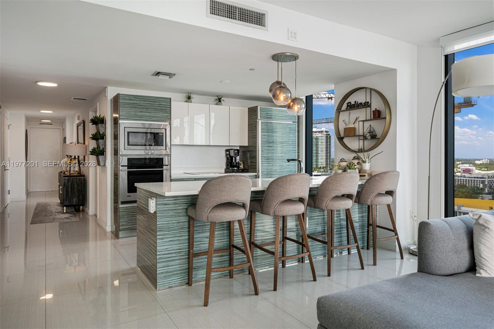 460 Northeast 28th Street, Unit 1901 Miami, FL 33137 - Photo 8 of 31 a dining hall with stainless steel appliances granite countertop a stove a dining table and chairs with wooden floor