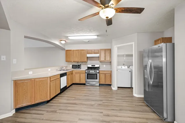 a large kitchen with a refrigerator and a stove top oven