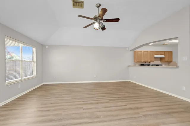 a view of a room with wooden floor and a ceiling fan