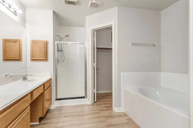 a bathroom with a granite countertop sink mirror and a bathtub