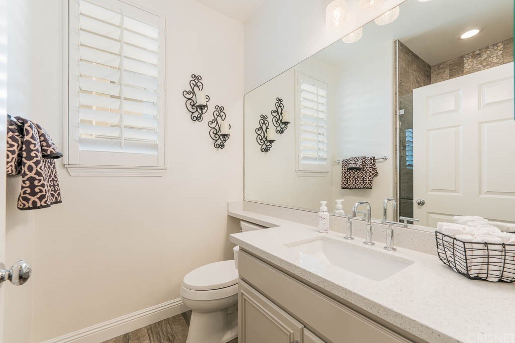 11564 Apulia Court Porter Ranch, CA 91326 - Photo 17 of 72 a bathroom with a granite countertop sink toilet and shower