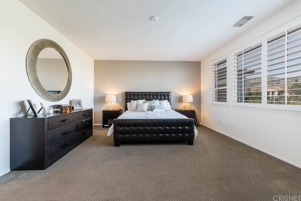 11564 Apulia Court Porter Ranch, CA 91326 - Photo 20 of 72 a bedroom with a bed a mirror on dresser and a table