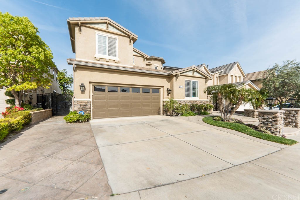 11564 Apulia Court Porter Ranch, CA 91326 - Photo 43 of 72 a front view of a house with a yard and potted plants