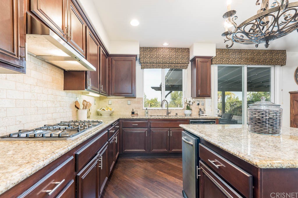 11564 Apulia Court Porter Ranch, CA 91326 - Photo 6 of 72 a kitchen with stainless steel appliances granite countertop a sink stove and cabinets