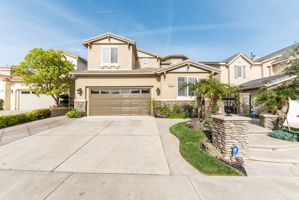 11564 Apulia Court Porter Ranch, CA 91326 - Photo 61 of 72 a front view of a house with a yard and garage
