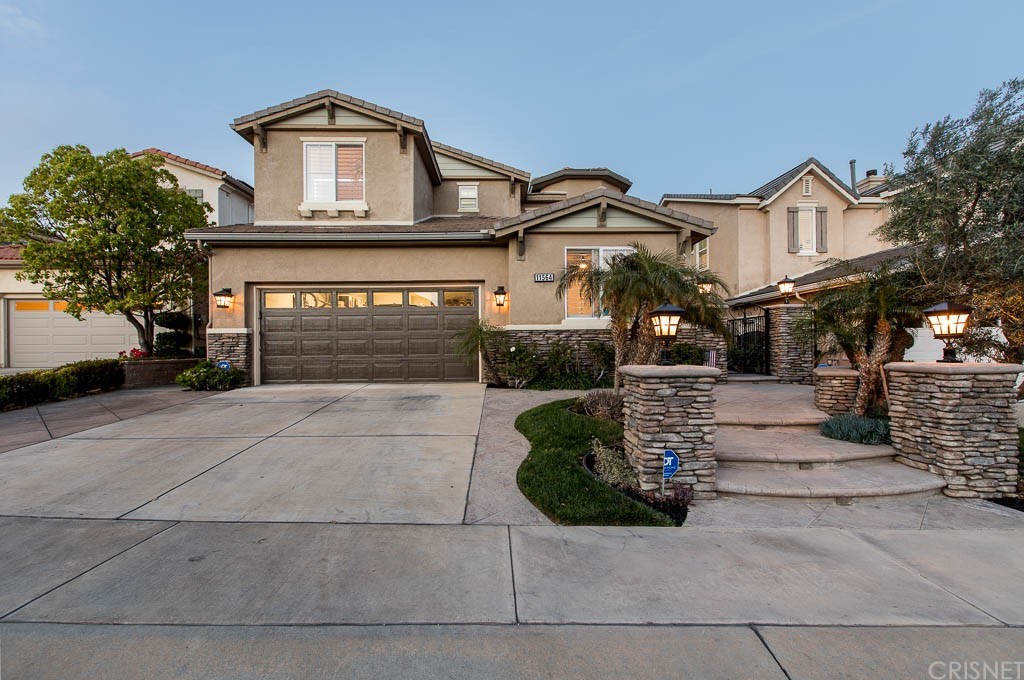 11564 Apulia Court Porter Ranch, CA 91326 - Photo 71 of 72 a front view of a house with a yard and garage