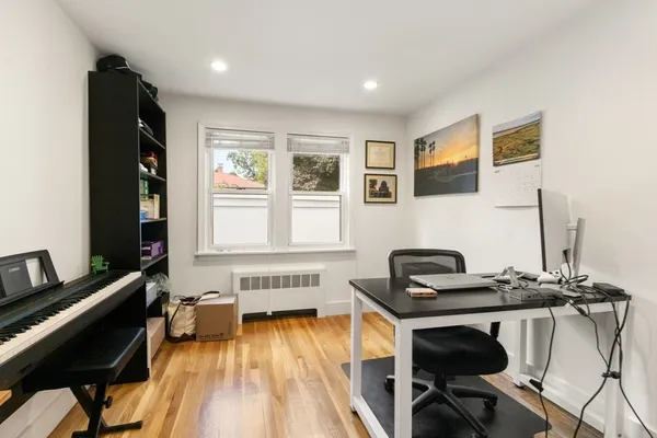 a view of a workspace with furniture and a window