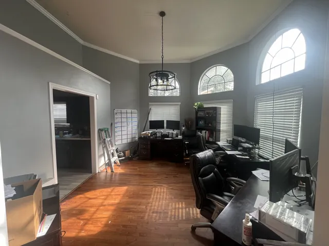 a living room with furniture a large window and a chandelier