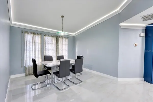 a dinning room with stainless steel appliances kitchen island granite countertop furniture a dining table and chairs