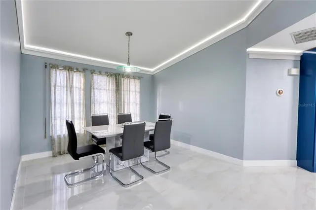 a dinning room with stainless steel appliances kitchen island granite countertop furniture a dining table and chairs