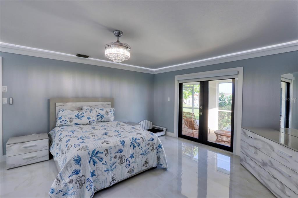 2500 Rio Lisbo Court Punta Gorda, FL 33950 - Photo 58 of 71 a bedroom with a large bed and a chandelier