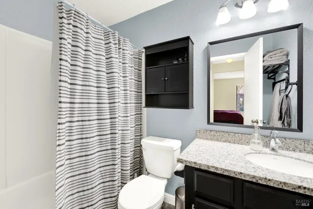 a bathroom with a granite countertop sink and a mirror