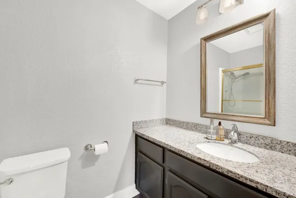 a bathroom with a granite countertop sink toilet and shower