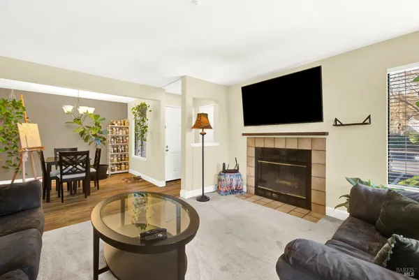 a living room with furniture a flat screen tv and a fireplace